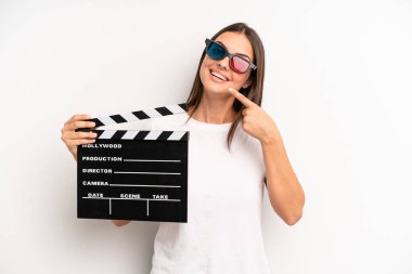 pretty woman smiling confidently pointing to own broad smile. movie or film concept