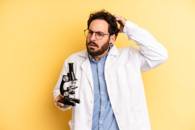 Genç adam mutlu bir şekilde gülümsüyor ve hayal kuruyor ya da şüphe ediyor. Scient öğrencisi