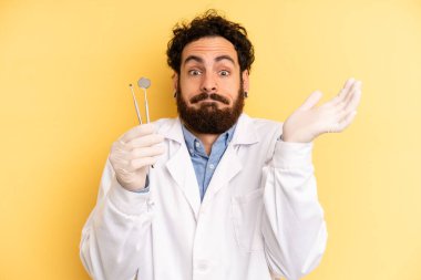 Genç adam şaşkın, şaşkın ve şüpheci hissediyor. dişçi kavramı