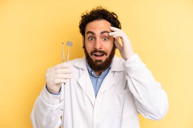 Genç adam mutlu, şaşkın ve şaşırmış görünüyor. dişçi kavramı