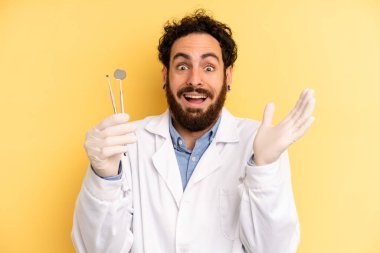 Genç adam kendini mutlu hissediyor ve inanılmaz bir şeye hayret ediyor. dişçi kavramı