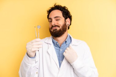 Genç adam kibirli, başarılı, pozitif ve gururlu görünüyor. dişçi kavramı