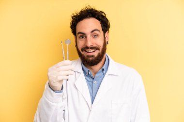 Genç adam mutlu ve hoş bir şekilde şaşırmış görünüyor. dişçi kavramı