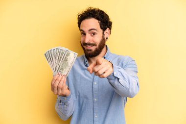 Genç adam kamerayı göstererek seni seçiyor. Dolar banknotları konsepti