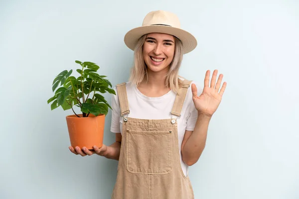 Blonde Woman Smiling Happily Waving Hand Welcoming Greeting You Gardering — Foto Stock