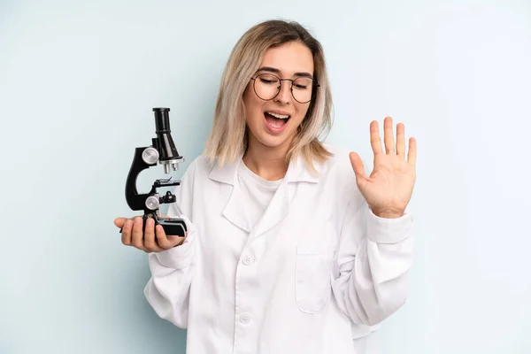 Blonde Vrouw Glimlachte Gelukkig Zwaaide Met Hand Verwelkomde Groette Wetenschappelijk — Stockfoto