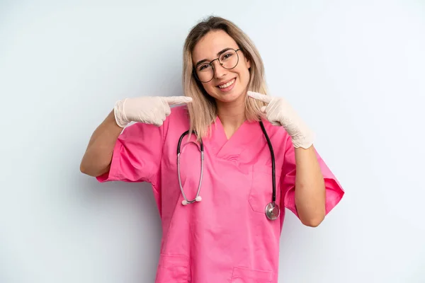 Blonde Woman Smiling Confidently Pointing Own Broad Smile Nurse Concept — Stockfoto