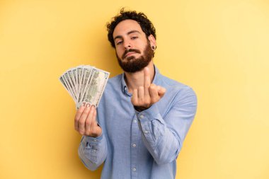 Genç adam kızgın, sinirli, asi ve agresif hissediyor. Dolar banknotları konsepti