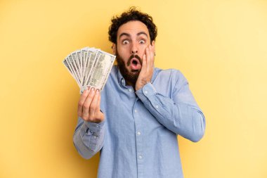 Genç adam şok olmuş ve korkmuş hissediyor. Dolar banknotları konsepti