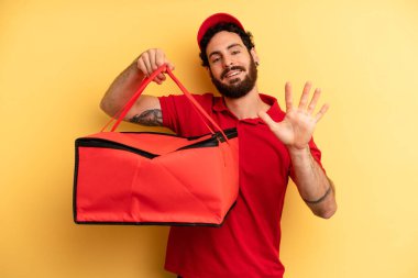 Genç adam gülümsüyor ve arkadaş canlısı görünüyor, beş numarayı gösteriyor. Pizza teslimatı kavramı