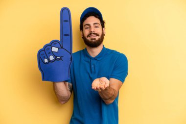Genç adam arkadaşça gülümsüyor ve bir konsept sunuyor. Bir el fan konsepti