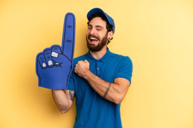 Genç adam kendini mutlu hissediyor ve bir meydan okumayla yüzleşiyor ya da kutluyor. Bir el fan konsepti