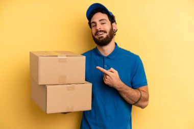 Genç adam neşeyle gülümsüyor, mutlu hissediyor ve bir tarafı işaret ediyor. Şirket çalışanı konsepti