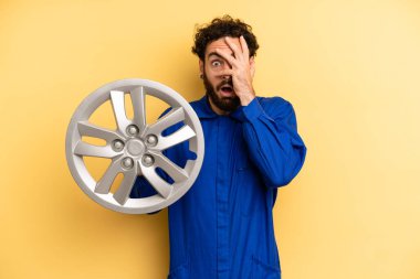 Delikanlı şok olmuş, korkmuş ya da korkmuş görünüyor, yüzünü eliyle kapatıyor. araba mekaniği kavramı