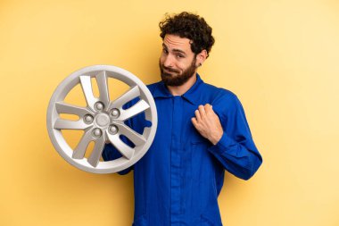 Genç adam kibirli, başarılı, pozitif ve gururlu görünüyor. araba mekaniği kavramı