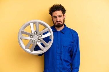 Genç adam üzgün ve mızmızlanıyor. Mutsuz bir bakışı var ve ağlıyor. araba mekaniği kavramı