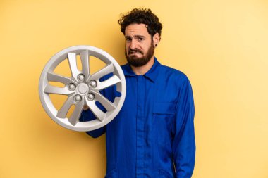 Genç adam şaşkın ve şaşkın görünüyor. araba mekaniği kavramı