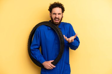 Genç adam sinirli, sinirli ve sinirli görünüyor. motor mekaniği kavramı