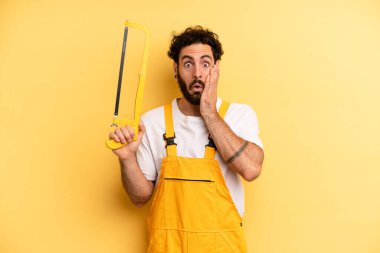 Genç adam şok olmuş ve korkmuş hissediyor. Testereli tamirci.