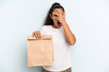 İspanyol kadın şok olmuş, korkmuş ya da dehşete düşmüş görünüyor, yüzünü elleriyle kapatıyor. konsepti kaldır