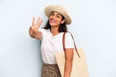 İspanyol kadın gülümsüyor ve arkadaş canlısı görünüyor, üç numarayı gösteriyor. yaz konsepti