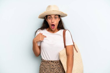 İspanyol kadın şok olmuş ve ağzı açık, kendini işaret ederek şaşırmış görünüyor. yaz konsepti