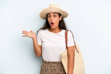 İspanyol kadın şaşırmış ve şok olmuş görünüyor. Çenesi düşmüş ve elinde bir nesne tutuyor. yaz konsepti