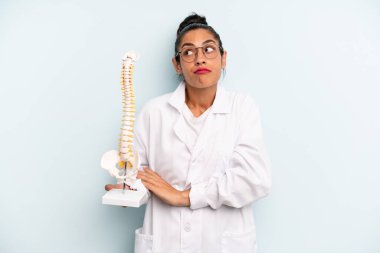 İspanyol kadın omuz silkiyor, kafası karışık ve kararsız. tıp öğrencisi konsepti