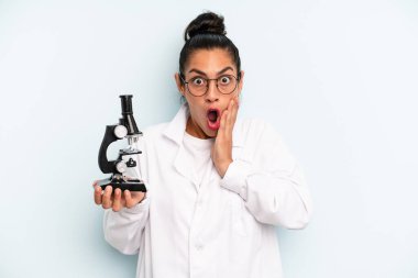 hispanic woman feeling shocked and scared. scients student