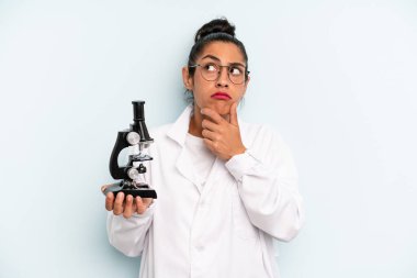 hispanic woman thinking, feeling doubtful and confused. scients student