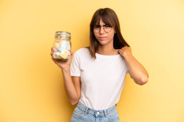 hispanic woman feeling stressed, anxious, tired and frustrated. candies bottle concept