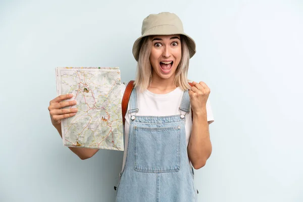 Blonde Woman Feeling Shocked Laughing Celebrating Success Tourist Map Concept — Zdjęcie stockowe