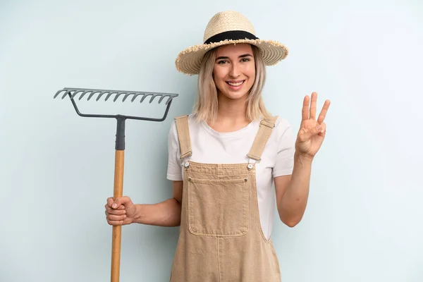 Blonde Vrouw Lacht Ziet Vriendelijk Uit Toont Nummer Drie Landbouwer — Stockfoto