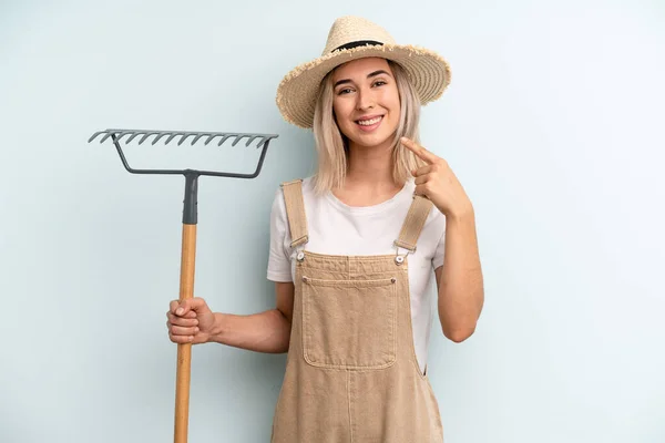 Blonde Woman Smiling Confidently Pointing Own Broad Smile Farmer Rake — Stockfoto