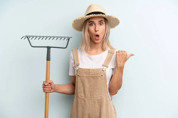 Blonde Woman Looking Astonished Disbelief Farmer Rake Cocnept — Stockfoto