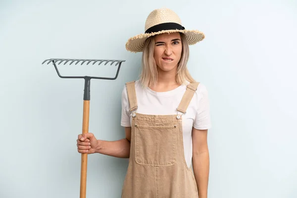 Blonde Woman Looking Puzzled Confused Farmer Rake Cocnept — Stockfoto