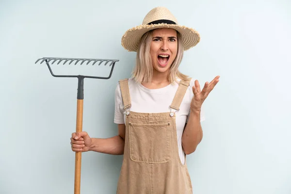 Blonde Vrouw Kijkt Wanhopig Gefrustreerd Gestrest Landbouwer Hark Gekaapt — Stockfoto