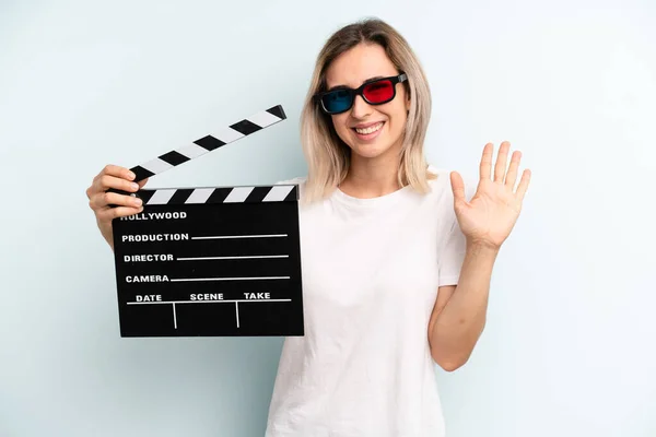 Blonde Woman Smiling Happily Waving Hand Welcoming Greeting You Film — Stok fotoğraf