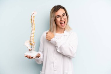 Sarışın kadın kendini mutlu hissediyor ve bir meydan okumayla yüzleşiyor ya da kutluyor. tıp öğrencisi konsepti