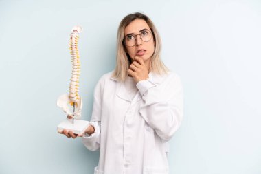 Sarışın kadın düşünüyor, kuşkulu ve şaşkın hissediyor. tıp öğrencisi konsepti