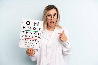 Sarışın kadın kendini mutlu hissediyor ve heyecanlı bir şekilde kendini işaret ediyor. optik görüş testi konsepti