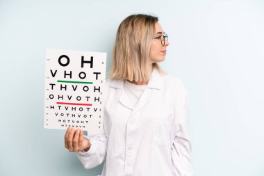 Profil bakışlı sarışın kadın hayal mi kuruyor yoksa hayal mi kuruyor? optik görüş testi konsepti