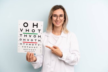 Sarışın kadın neşeyle gülümsüyor, mutlu hissediyor ve bir tarafı işaret ediyor. optik görüş testi konsepti