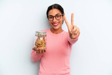 İspanyol kadın gülümsüyor ve mutlu görünüyor, zafer ya da barış işareti yapıyor. Ev yapımı kurabiye konsepti