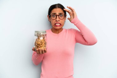 İspanyol kadın kendini stresli, endişeli ya da korkmuş hissediyor, elleri başının üstünde. Ev yapımı kurabiye konsepti