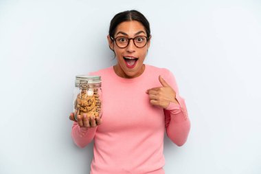 İspanyol kadın kendini mutlu hissediyor ve heyecanla kendini işaret ediyor. Ev yapımı kurabiye konsepti