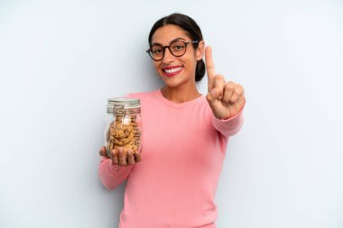 Hispanik kadın gururla gülümsüyor ve kendinden emin bir numara oluyor. Ev yapımı kurabiye konsepti