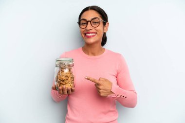 İspanyol kadın neşeyle gülümsüyor, mutlu hissediyor ve bir tarafı işaret ediyor. Ev yapımı kurabiye konsepti