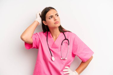 Güzel bir kadın mutlu bir şekilde gülümsüyor ve hayal kuruyor ya da şüphe ediyor. hemşire konsepti