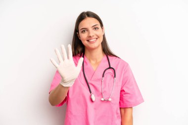 Güzel bayan gülümsüyor ve arkadaş canlısı görünüyor, beş numarayı gösteriyor. hemşire konsepti